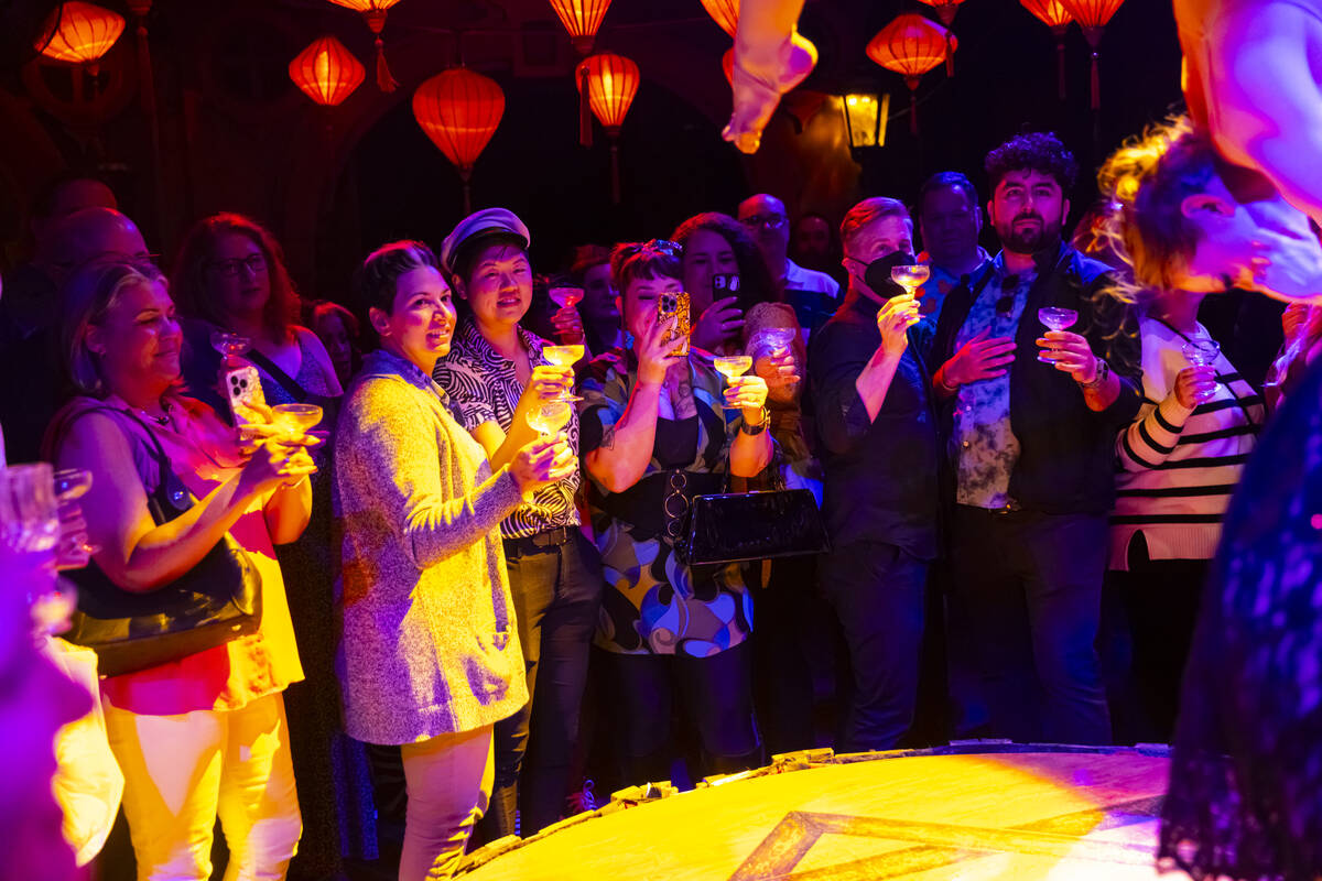 Attendees raise their glasses for aerial pours of rum during the closing night of Lost Spirits ...