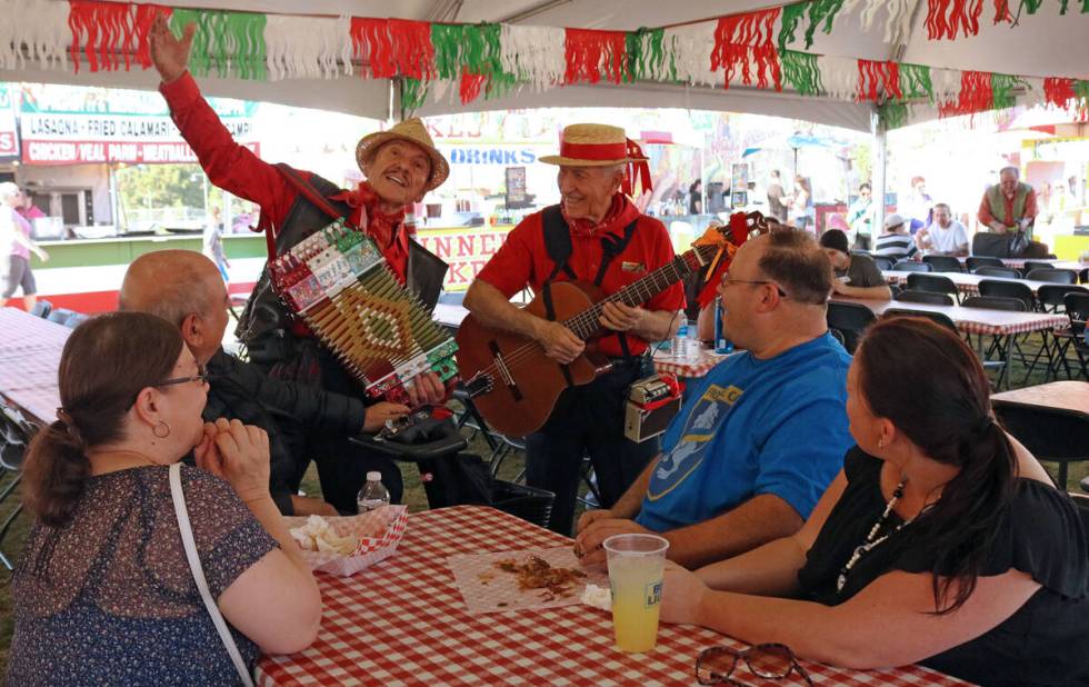 Emilio Baglioni, left, and Aldo Vallera serenade a group of people during the San Gennaro Feast ...