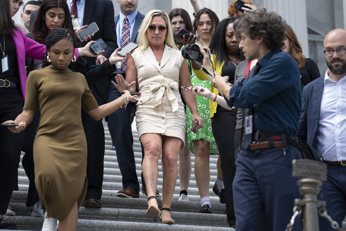Rep. Marjorie Taylor Greene, R-Ga., is followed by reporters as she walks down the steps at the ...