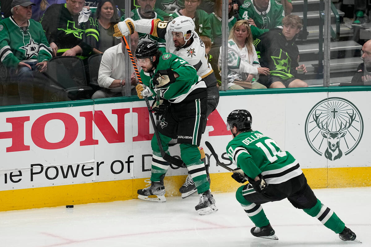 Dallas Stars' Chris Tanev (3) and Ty Dellandrea (10) work to keep the puck away from Vegas Gold ...