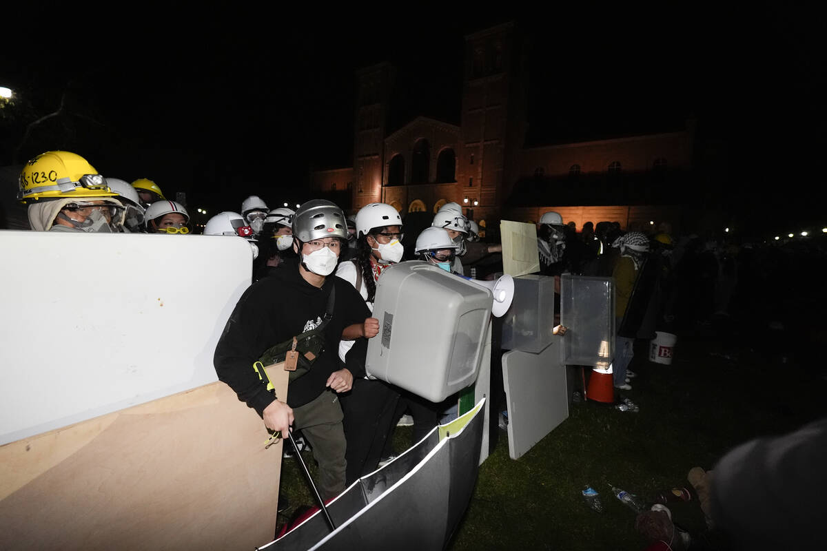 Pro-Palestinian demonstrators use makeshift shields as police advance on them on the UCLA campu ...