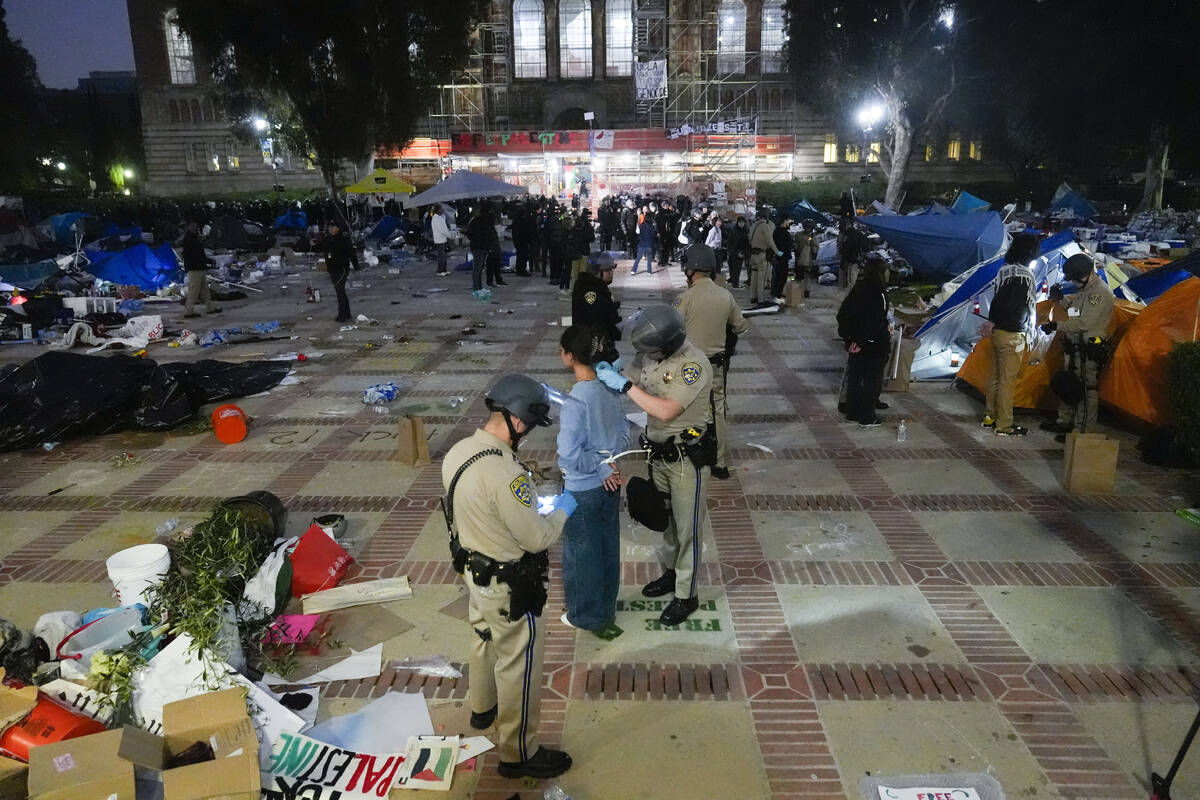 Pro-Palestinian demonstrators are detained on the UCLA campus Thursday, May 2, 2024, in Los Ang ...