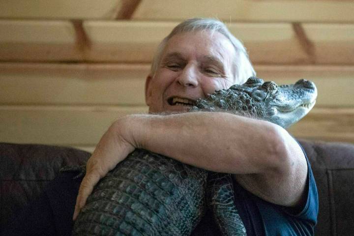 Joie Henney hugs his emotional support alligator named Wally, Jan. 22, 2019, inside their home ...