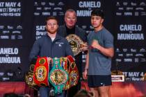 Boxer Canelo Alvarez holds many of his belts with an assist by promotor Tom Brown beside oppone ...