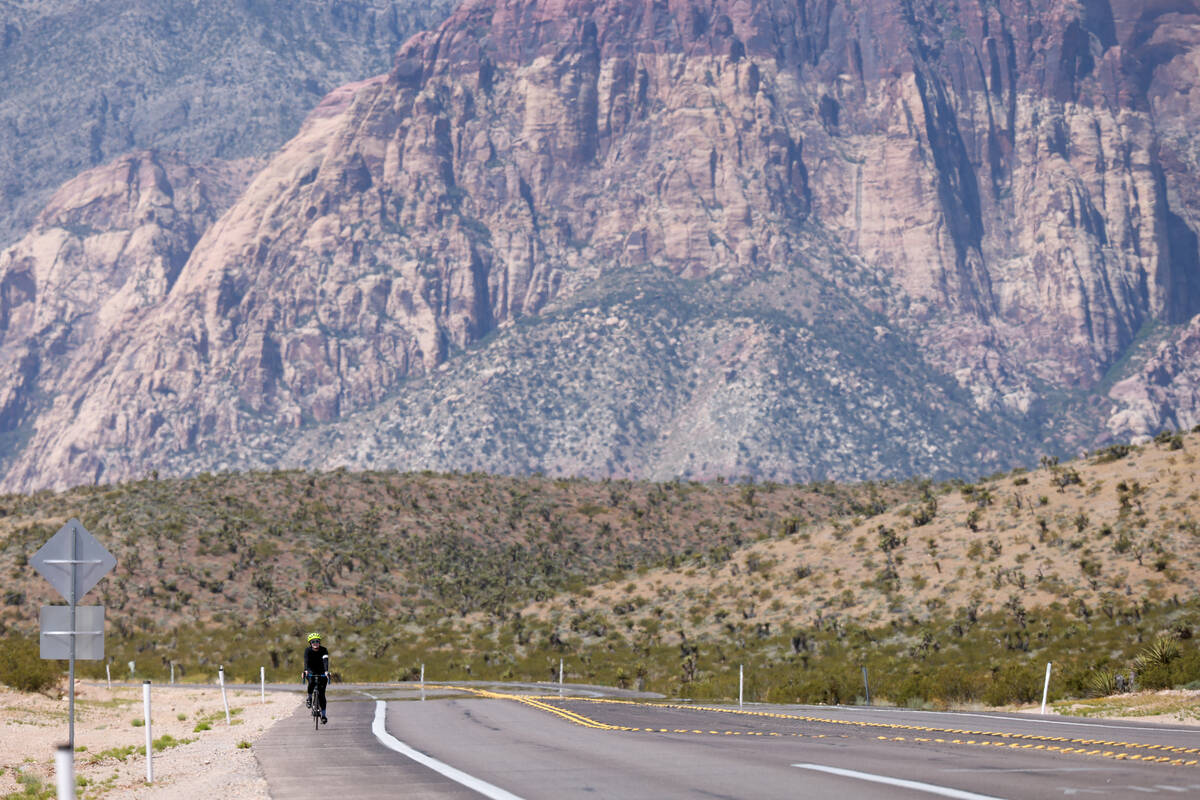 A cyclist moves along State Route 159 near Calico Basin Road in Red Rock Canyon National Conser ...