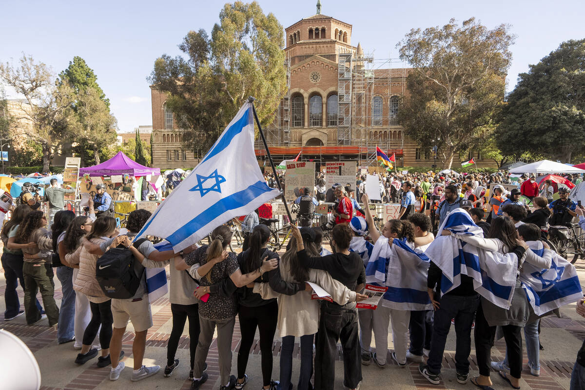 FILE - A group of pro-Israel supporters hold arms as they sing and dance outside a pro-Palestin ...