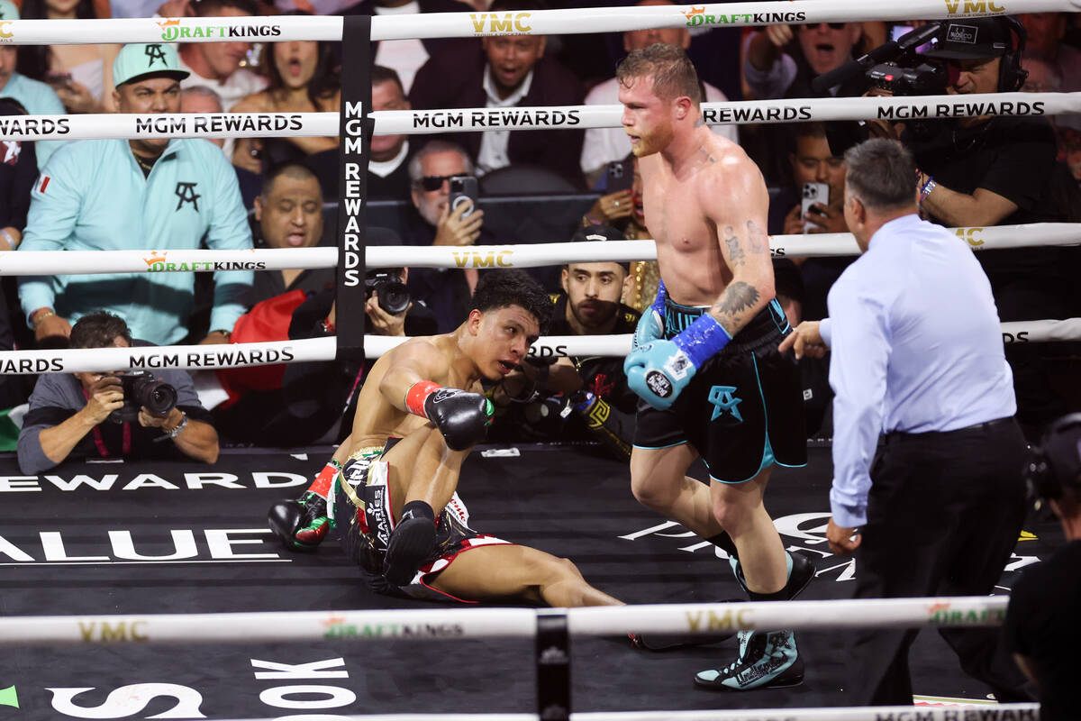 Jaime Munguía falls to the mat after taking a hit from Canelo Álvarez during an undis ...