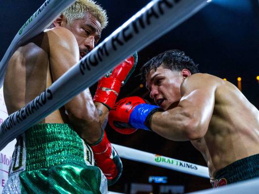 Featherweight Jessie Magdaleno is driven into the ropes by Brandon Figueroa during the fourth r ...