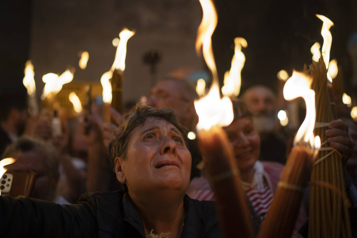 A Christian Orthodox pilgrim holds a candle during the Holy Fire ceremony at the Church of the ...