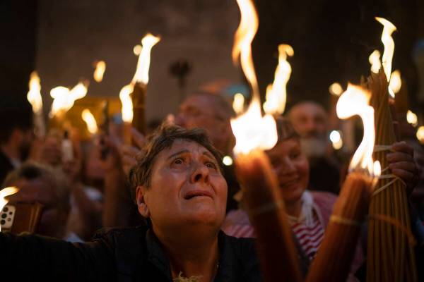 A Christian Orthodox pilgrim holds a candle during the Holy Fire ceremony at the Church of the ...