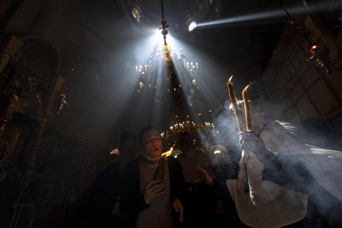 Christian pilgrims hold candles as they gather during the ceremony of the Holy Fire at the Chur ...