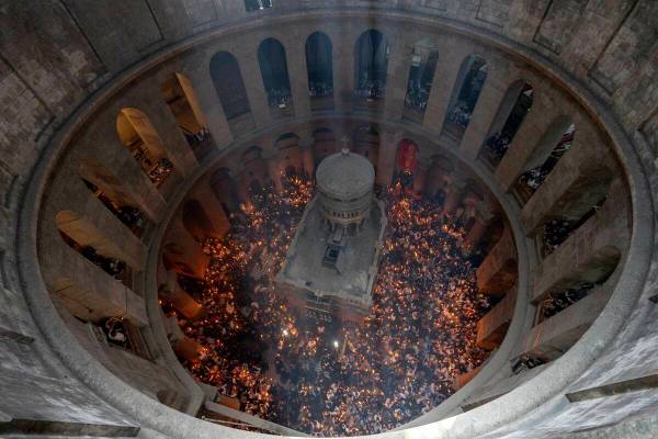 Christian pilgrims hold candles during the Holy Fire ceremony, a day before Easter, at the Chur ...