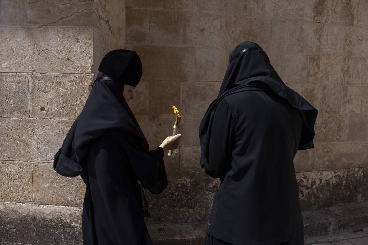 Greek Orthodox nuns hold candles as they gather during the ceremony of the Holy Fire at the Chu ...