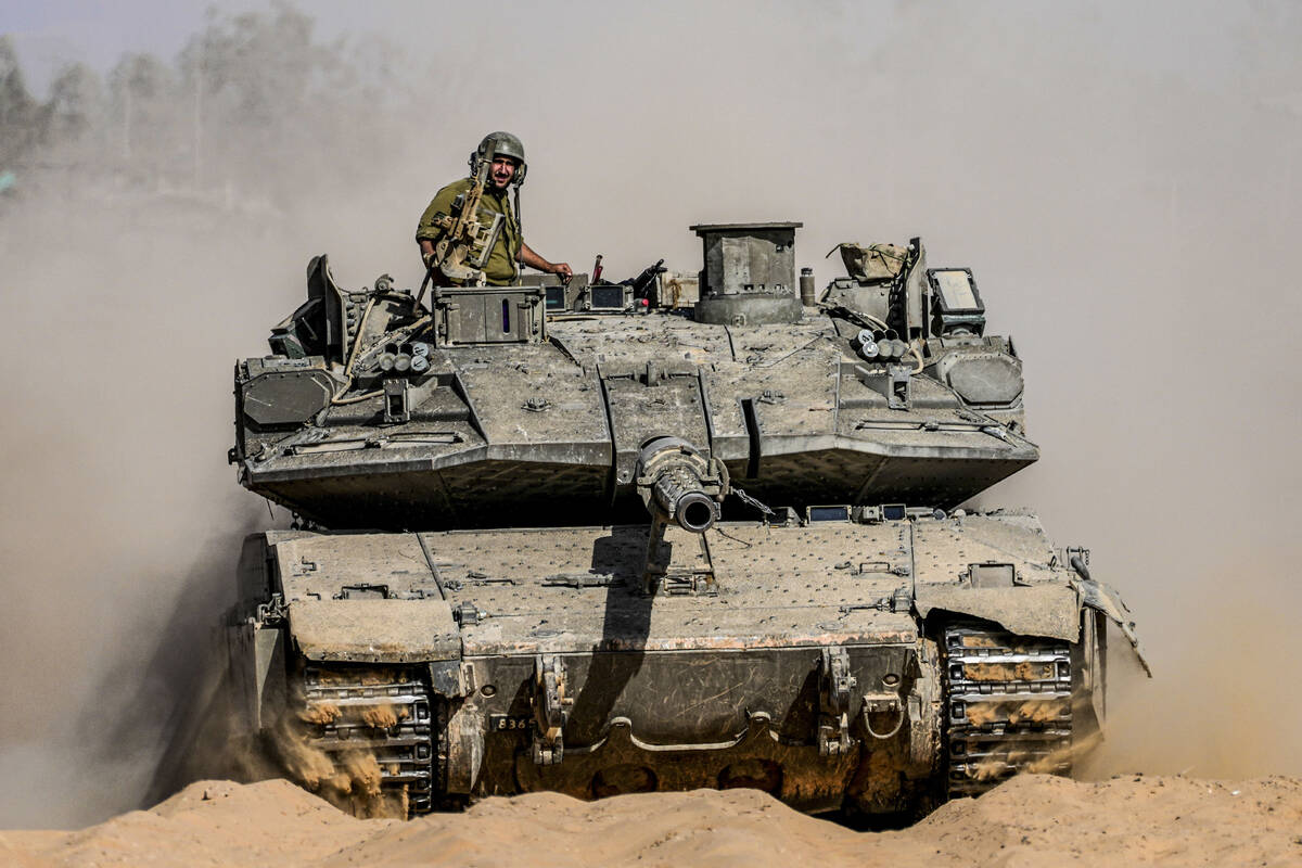 Israeli soldiers drive a tank at a staging ground near the border with the Gaza Strip, in south ...