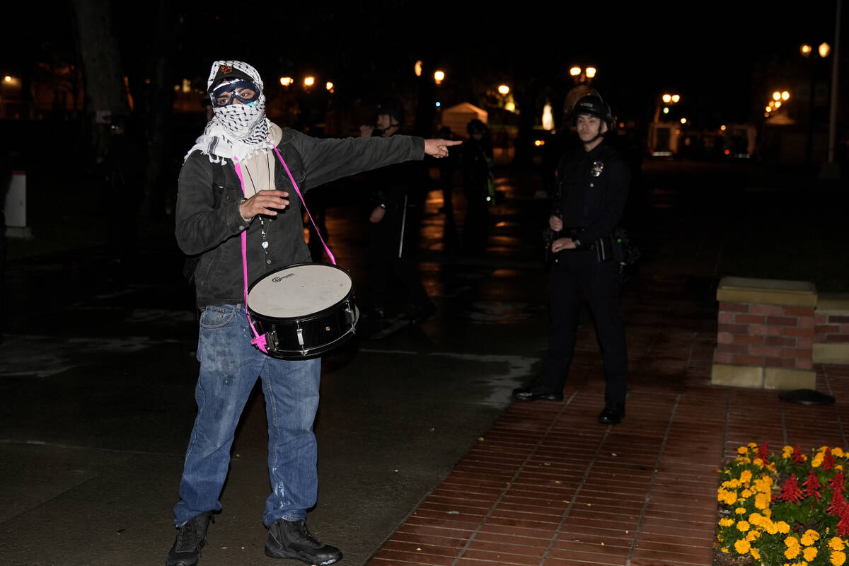 A protestors gestures near police officers after a raid on the pro-Palestinian encampment on th ...