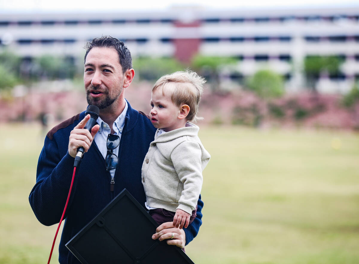 Clark County Commissioner Michael Naft addresses the audience while holding his son, Ari Naft, ...
