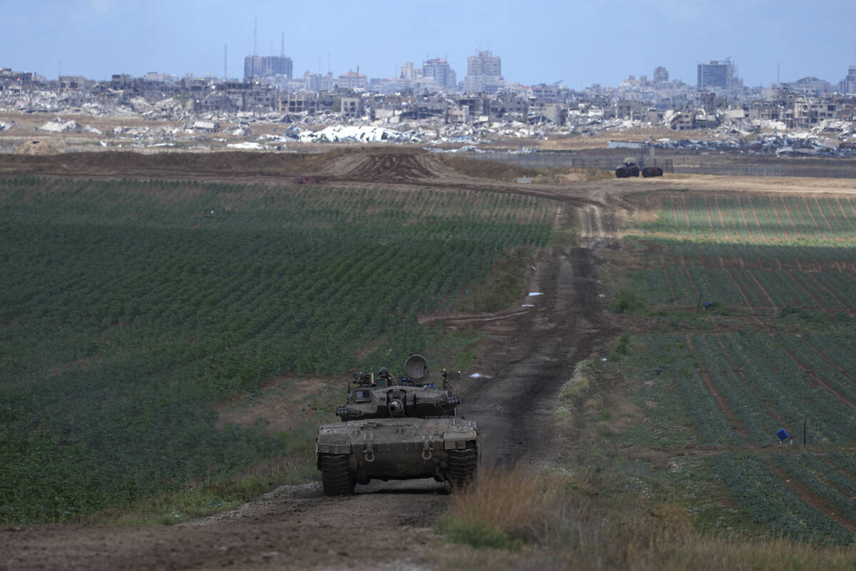 An Israeli Defense Forces tank drives away from the Gaza Strip, as seen from southern Israel, M ...