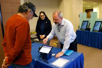 Dan Kulin, right, Clark County's manager of election administration, demonstrates how to regist ...