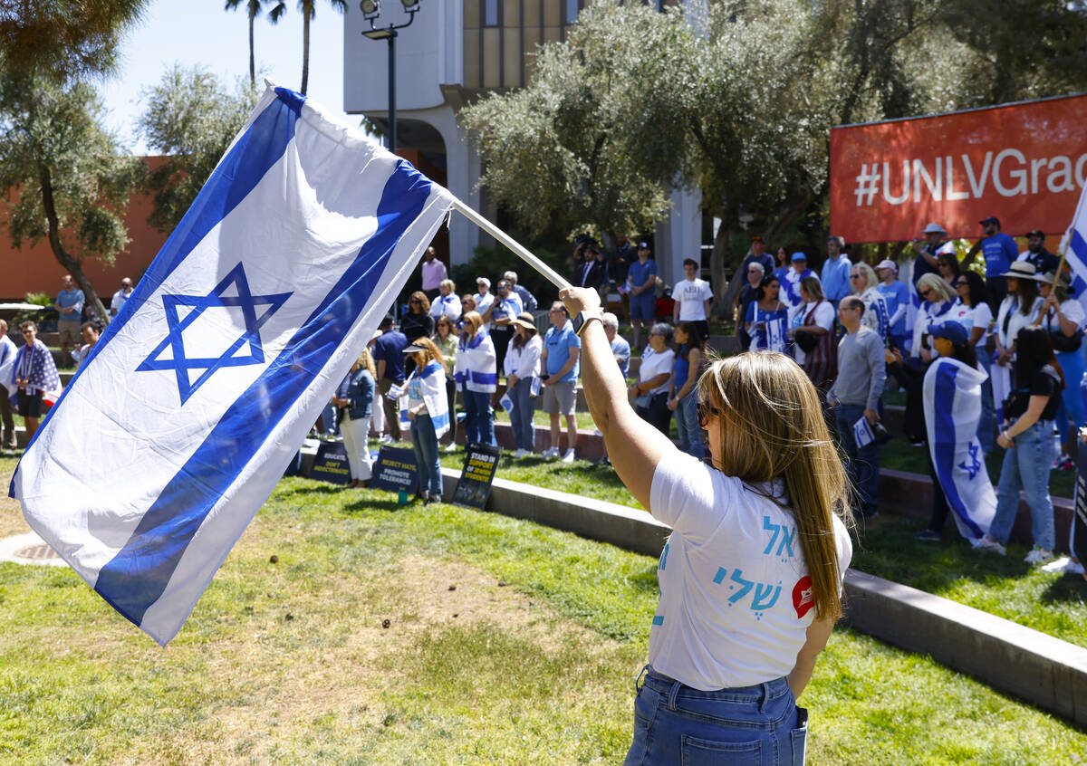 Ofra Etzion, a regional director of Israeli-American Council, waves Israeli flag during Stand ...
