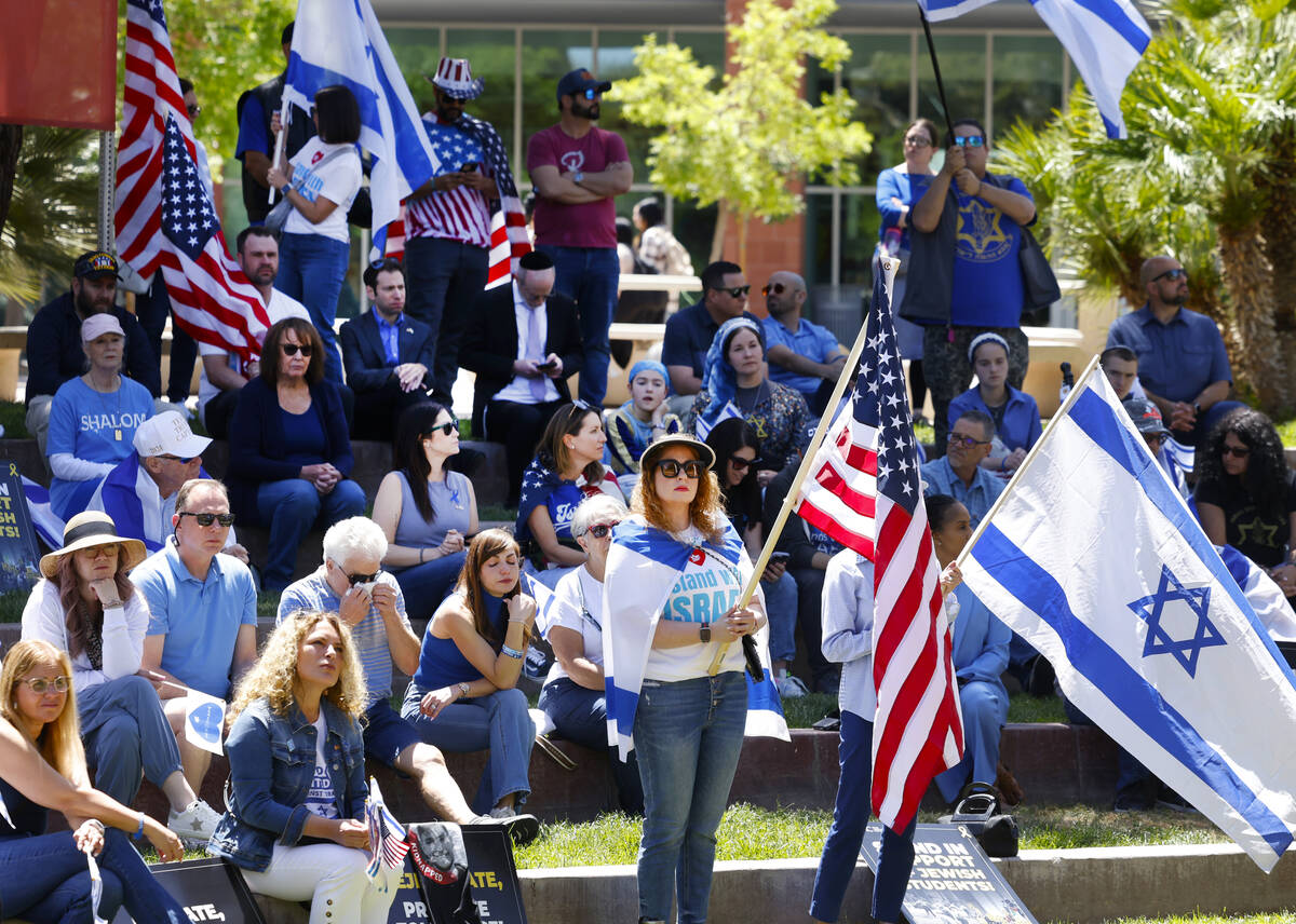 Jennifer Courier, center, holds a U.S. flag while joining others at the Stand Against Hate Rall ...