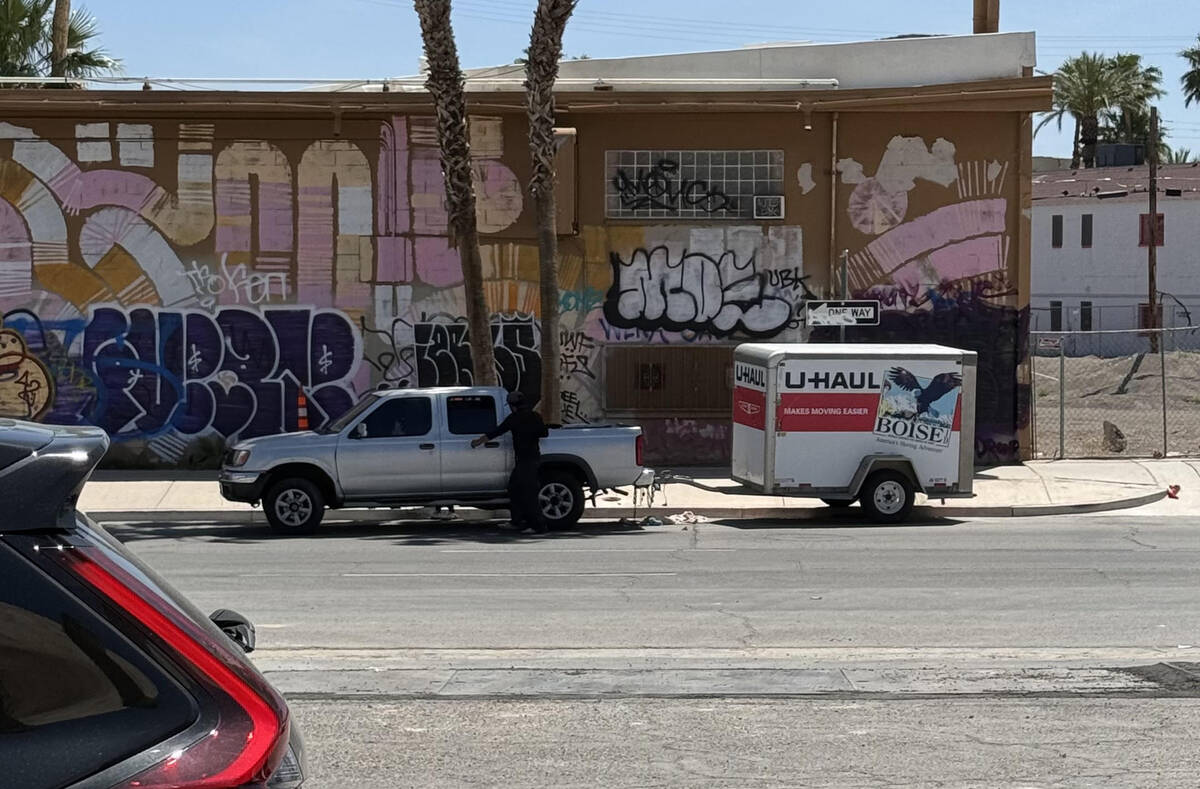 An unidentified man adjusts the rear end of his Nissan Frontier pickup and U-Haul trailer after ...