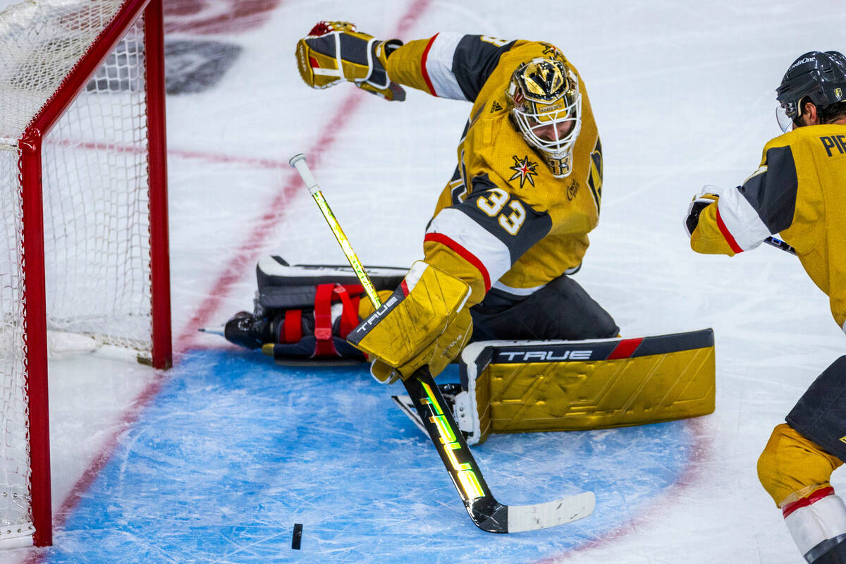 Golden Knights goaltender Adin Hill (33) pokes away a shot by the Dallas Stars during the secon ...