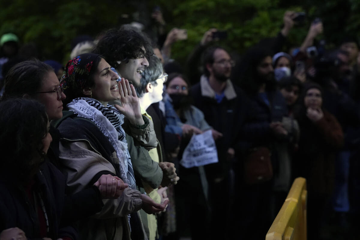 Pro-Palestinian protesters chat as police kept them away from the university's quad while the s ...