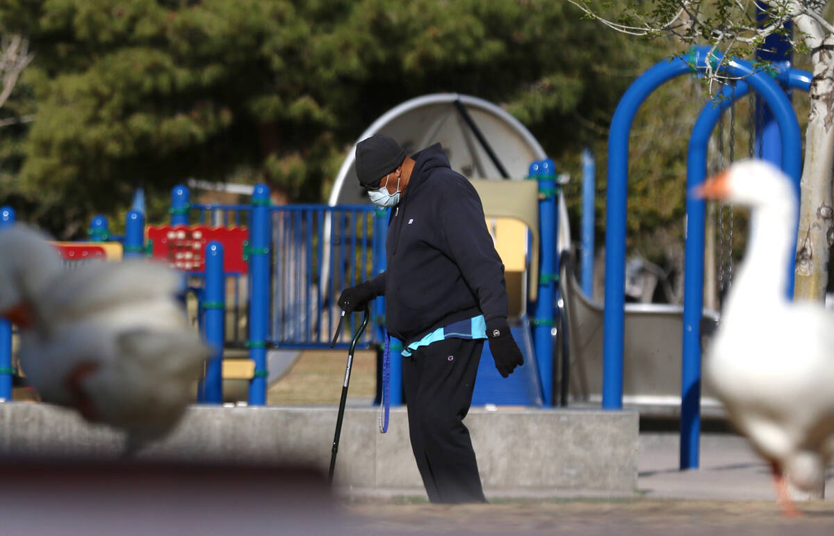 A man, who declined to give his name, wears protective masks as he walks at Sunset Park on Wedn ...