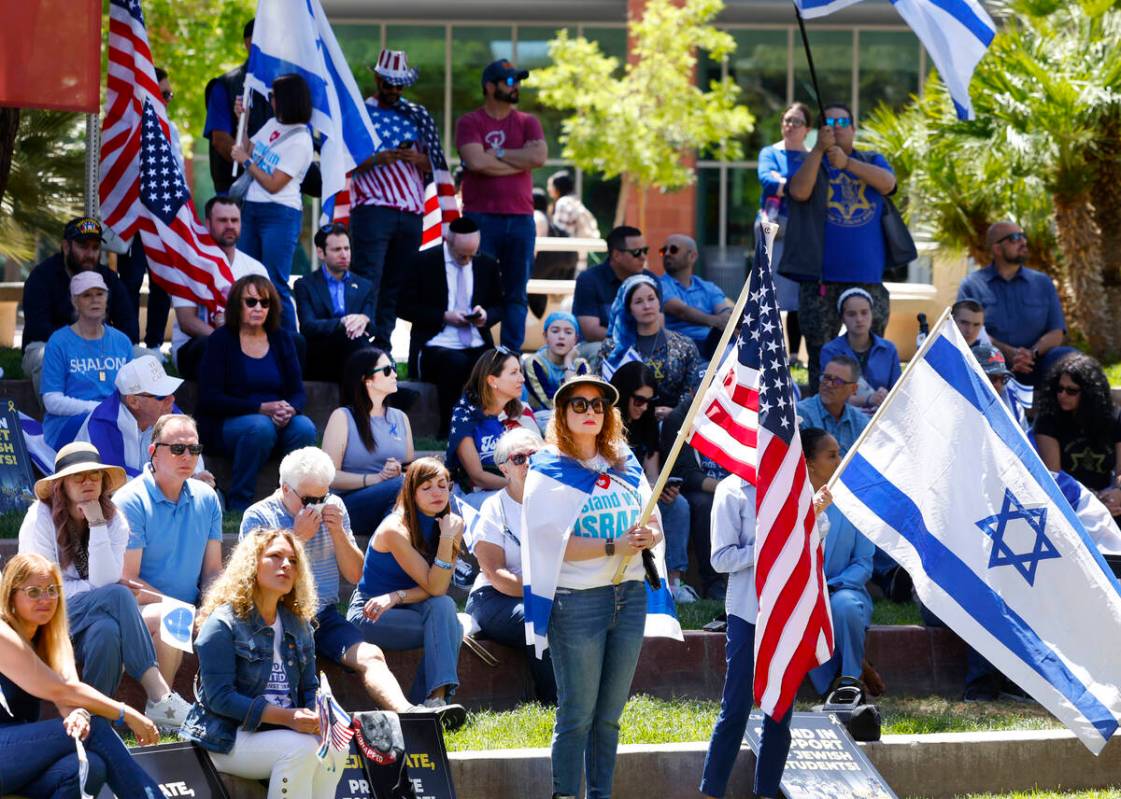 Jennifer Courier, center, holds a U.S. flag while joining others at a rally against antisemitis ...