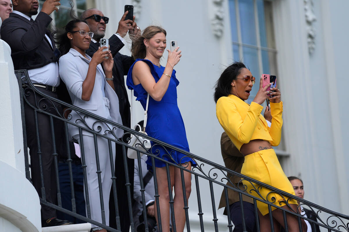 A'ja Wilson, of the 2023 WNBA champion Las Vegas Aces, right, watches as President Joe Biden ta ...