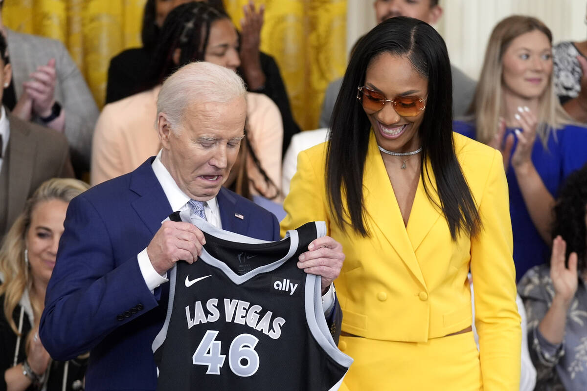 A'ja Wilson, of the WNBA's Las Vegas Aces, right, presents a jersey to President Joe Biden duri ...