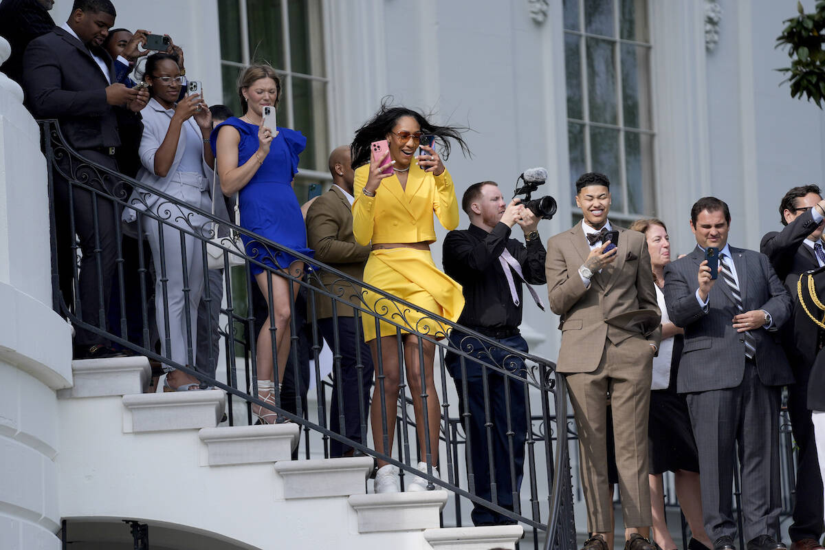 A'ja Wilson, of the 2023 WNBA champion Las Vegas Aces, center, watches as President Joe Biden w ...