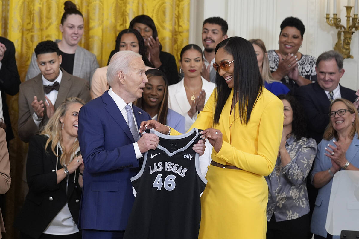 A'ja Wilson, of the WNBA's Las Vegas Aces, right, presents a jersey to President Joe Biden duri ...