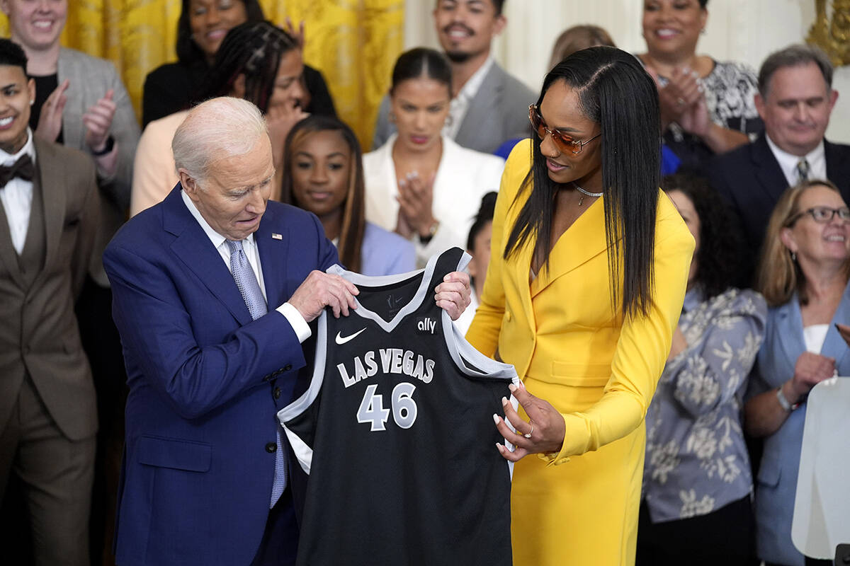 A'ja Wilson, of the WNBA's Las Vegas Aces, right, presents a jersey to President Joe Biden duri ...