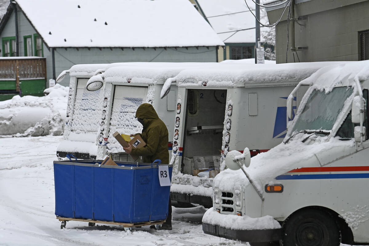 A mail carrier loads a mail truck with mail, March 1, 2024, in Lake Tahoe. (AP Photo/Andy Barro ...