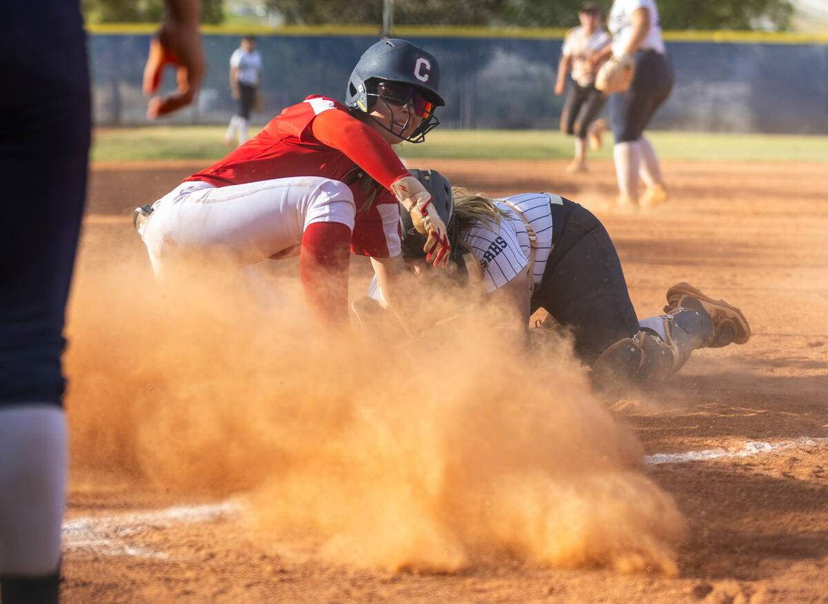 Coronado runner Bailey Goldberg (1) slides safely around a late tag attempt at home plate by Sh ...
