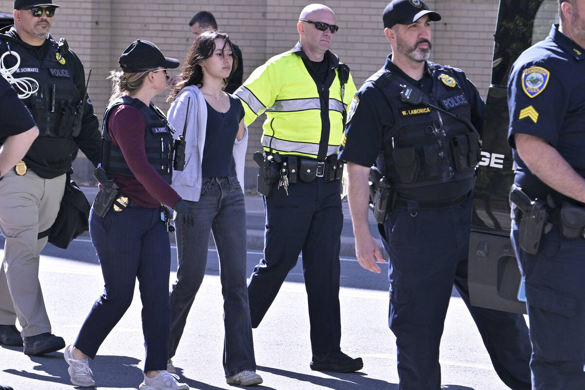 Police detain a pro-Palestinian demonstrator who attempted to block traffic from the garage of ...