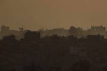 Destroyed buildings in the Gaza Strip are seen during the sunset from southern Israel, Thursday ...