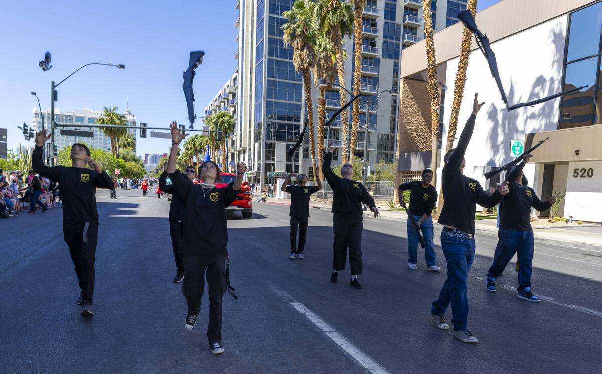 Members of the Sierra Vista High School Army JROTC Drill Team toss their rifles in the air as t ...