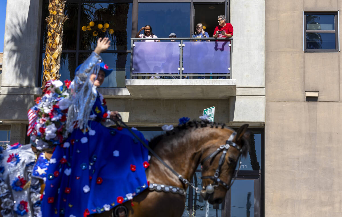 Crowd members watch from a balcony above along the route during the Helldorado Parade moving up ...