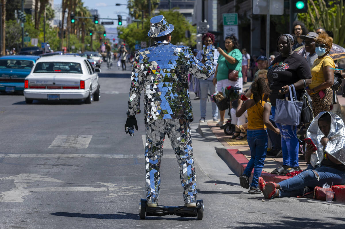 A man in a mirrored suit waves to the the crowd along the route during the Helldorado Parade mo ...