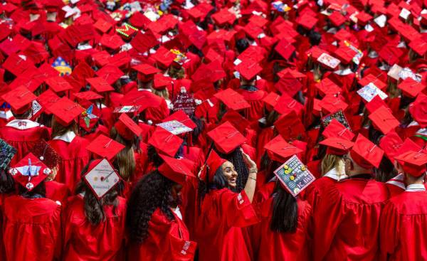 A graduate waves to supporters in the crowd during UNLV spring graduation commencement exercise ...