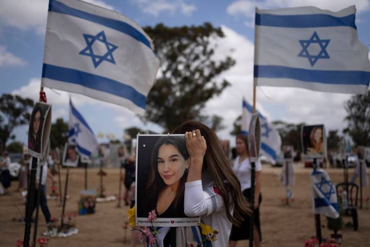 A woman touches a picture of a relative as she attends the celebrations of the Israel's annual ...