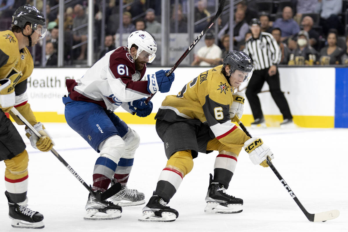 Golden Knights defenseman Kaedan Korczak (6) skates with the puck next to Avalanche forward Mar ...