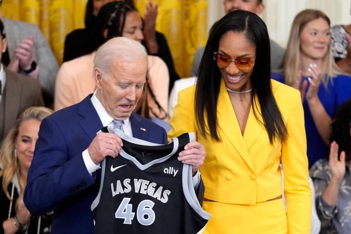 A'ja Wilson, of the WNBA's Las Vegas Aces, right, presents a jersey to President Joe Biden duri ...