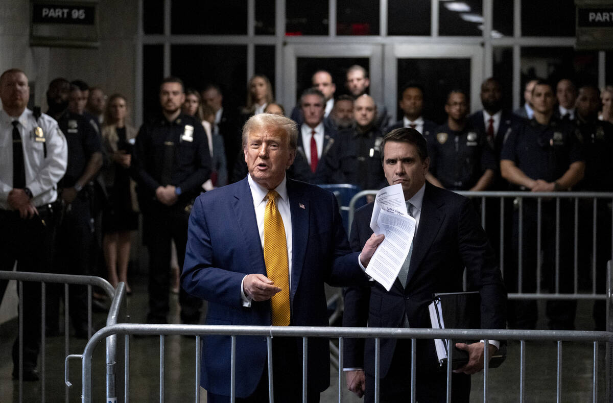 Former President Donald Trump, standing with defense attorney Todd Blanche, speaks after a cour ...