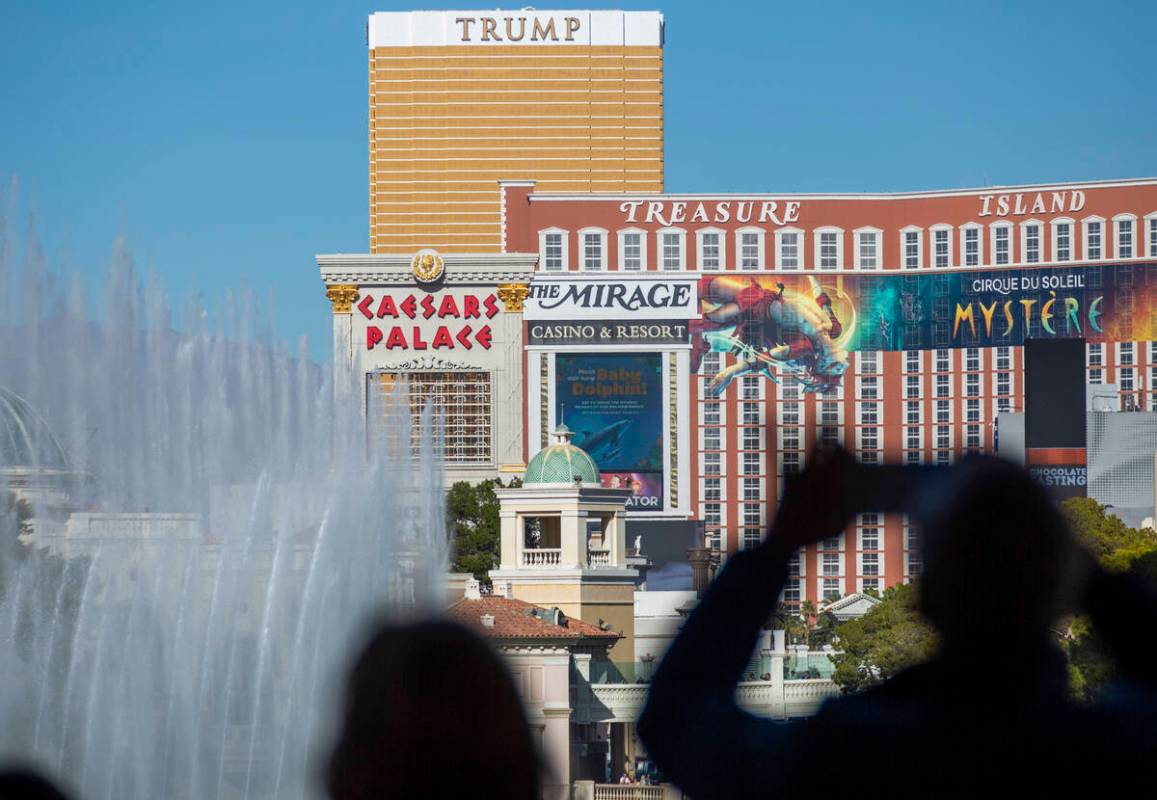 Tourists take photos of the fountains at Bellagio along the Strip in Las Vegas on Monday, Nov. ...