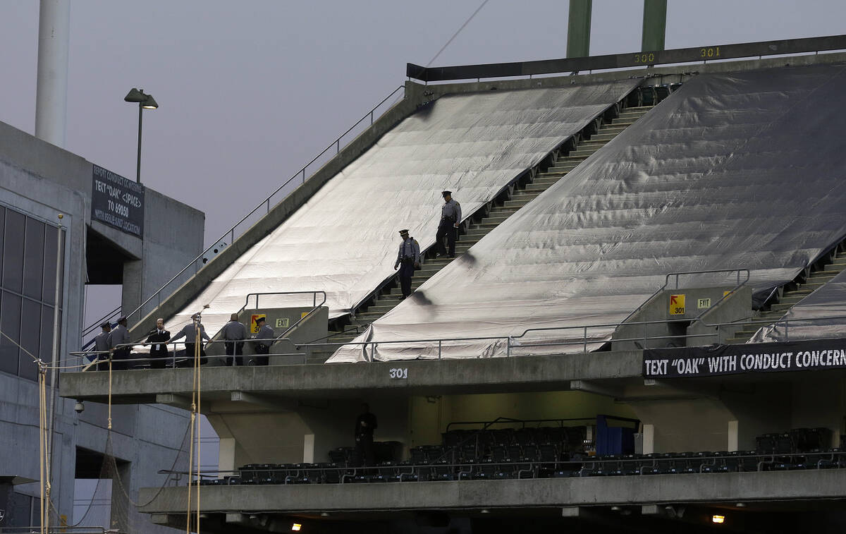 Law enforcement officials walk in the upper deck of Oakland Coliseum after an NFL football game ...