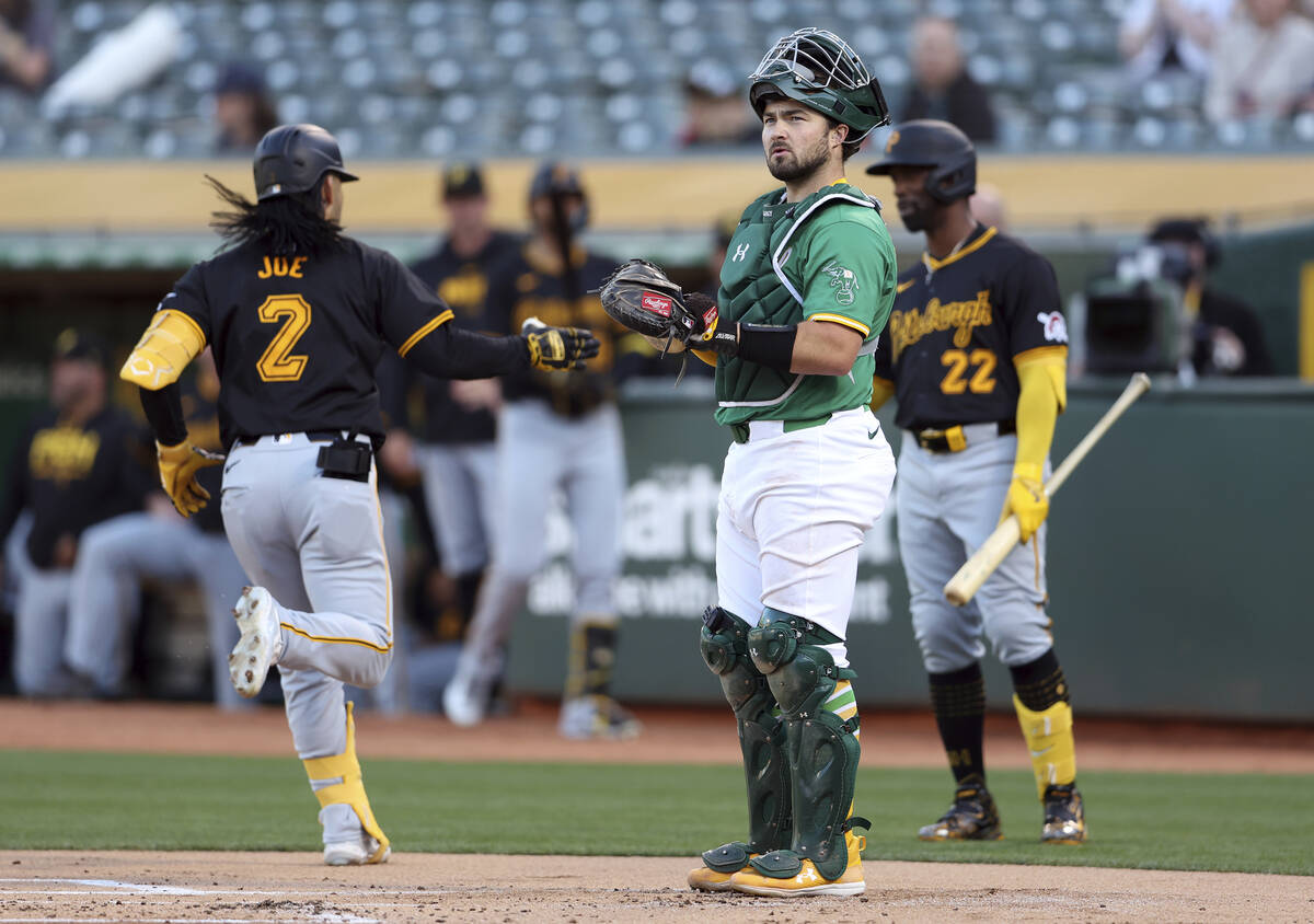 Oakland Athletics' Shea Langeliers looks away as Pittsburgh Pirates' Connor Joe crosses home pl ...