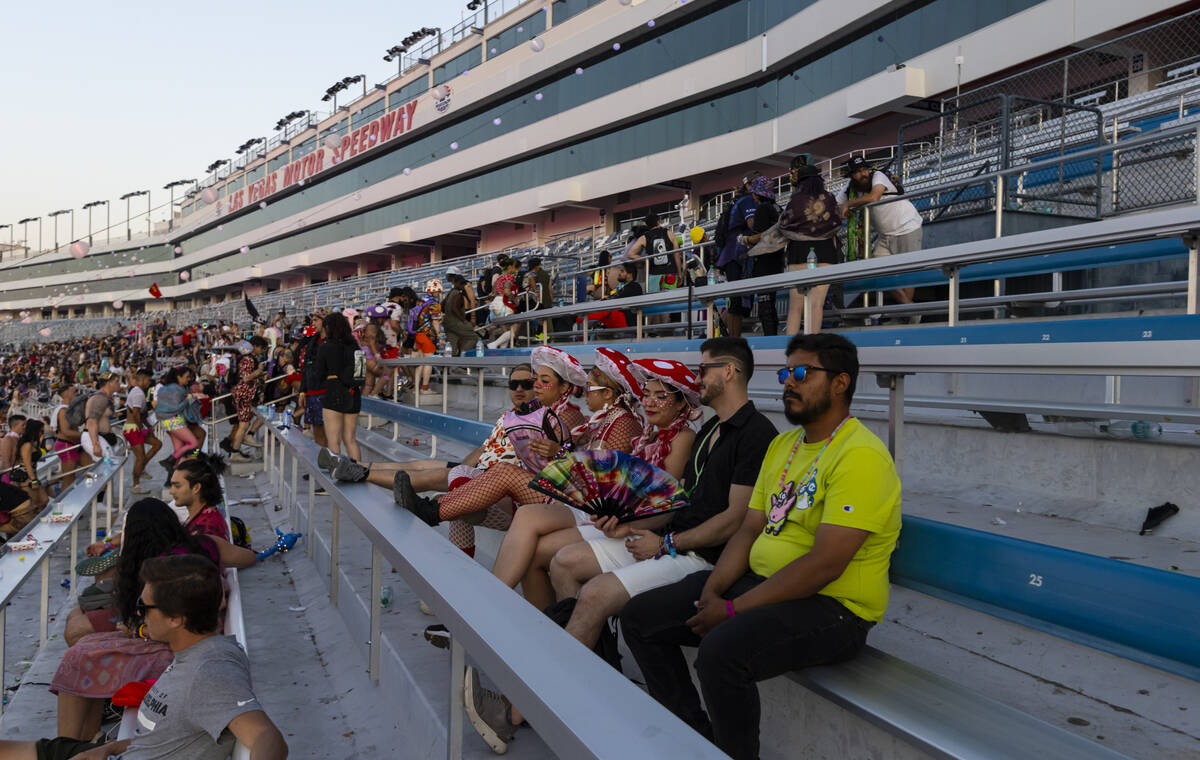 Festival attendees sit as others make their way towards the exits at sunrise on the close of th ...